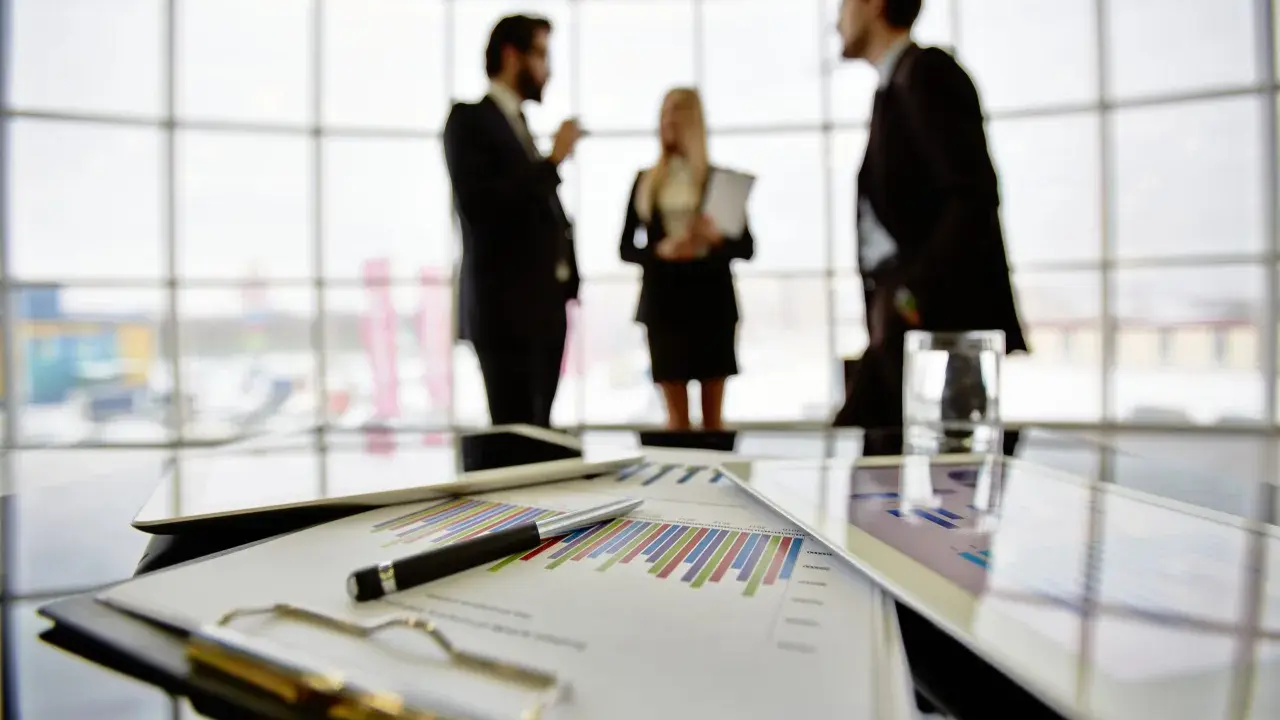 Een team bespreekt grafieken en cijfers, een vooruitblik op wat je kunt worden met bedrijfskunde: manager, strateeg of ondernemer.
