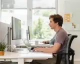 Jonge man werkt geconcentreerd aan laptop. Dit is een voorbeeld van self assessment betekenis: reflecteren op eigen werk.