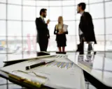 Een team bespreekt grafieken en cijfers, een vooruitblik op wat je kunt worden met bedrijfskunde: manager, strateeg of ondernemer.