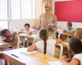 Een lerares geeft les aan een klas, waarbij ze de principes van psychologie in het onderwijs toepast om leerlingen te betrekken.