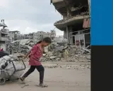 Een meisje sleept een kar met spullen door de verwoesting van de oorlog in Gaza. Gebouwen liggen in puin, een triest beeld van de impact op burgers.