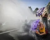 Protest met waterkanonnen, mensen met paraplu's tonen burgerlijke ongehoorzaamheid.