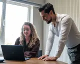 Man en vrouw kijken samen naar een laptop, ter voorbereiding op een gesprek met HR.