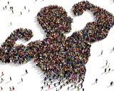 Een grote groep mensen vormt de gestalte van een gespierde arm, wat de kracht van de massa symboliseert. Dit beeld roept vragen op over wat is populisme en hoe de massa wordt gemobiliseerd.