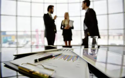 Een team bespreekt grafieken en cijfers, een vooruitblik op wat je kunt worden met bedrijfskunde: manager, strateeg of ondernemer.