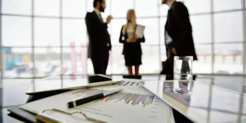 Een team bespreekt grafieken en cijfers, een vooruitblik op wat je kunt worden met bedrijfskunde: manager, strateeg of ondernemer.