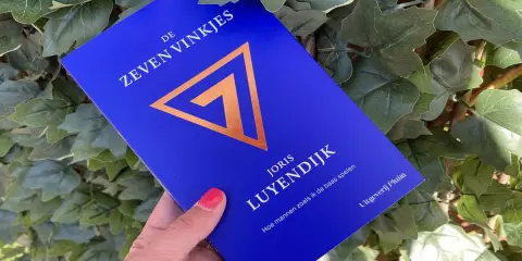 Blauwe kaft met gouden symbool en tekst "De Zeven Vinkjes" van Joris Luyendijk.