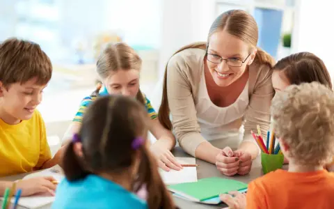 Docente begeleidt kinderen bij creatieve check-in werkvormen onderwijs. Kleurrijke potloden en notitieboekjes op tafel.
