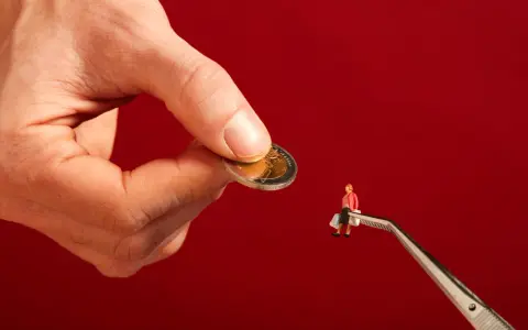 Een hand houdt een munt vast, terwijl een pincet een miniatuurfiguur met boodschappentassen vasthoudt. Dit symboliseert hoe een filantroop helpt.