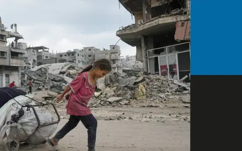 Een meisje sleept een kar met spullen door de verwoesting van de oorlog in Gaza. Gebouwen liggen in puin, een triest beeld van de impact op burgers.