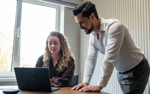 Man en vrouw kijken samen naar een laptop, ter voorbereiding op een gesprek met HR.