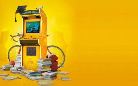 Een arcadekast met een afstudeerhoed en diploma, omringd door boeken, een fiets en een basketbal. Dit symboliseert game based learning.