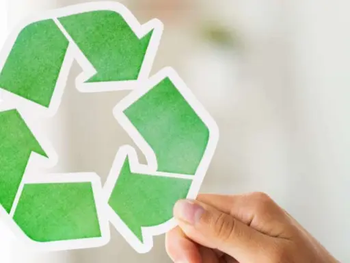 Hand holds a green recycling symbol, representing duurzaam ondernemen.