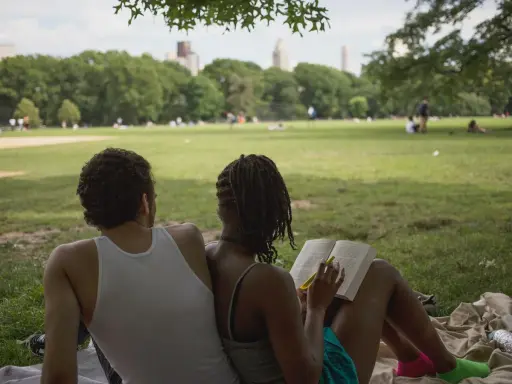Een stel geniet van een zonnige dag in het park. Ze zitten op een kleed, de vrouw leest een boek, de man kijkt naar het landschap. Ze hebben de derde plaats in de wedstrijd 'meest ontspannen duo'.
