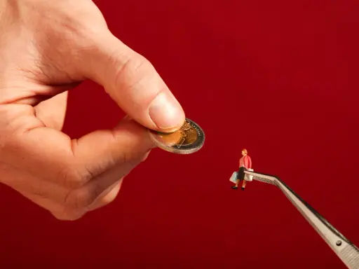 Een hand houdt een munt vast, terwijl een pincet een miniatuurfiguur met boodschappentassen vasthoudt. Dit symboliseert hoe een filantroop helpt.