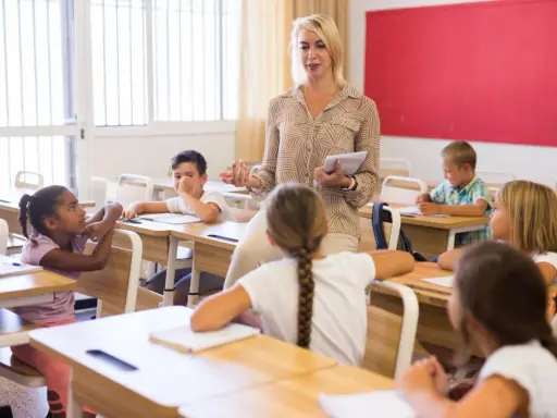 Een lerares geeft les aan een klas, waarbij ze de principes van psychologie in het onderwijs toepast om leerlingen te betrekken.