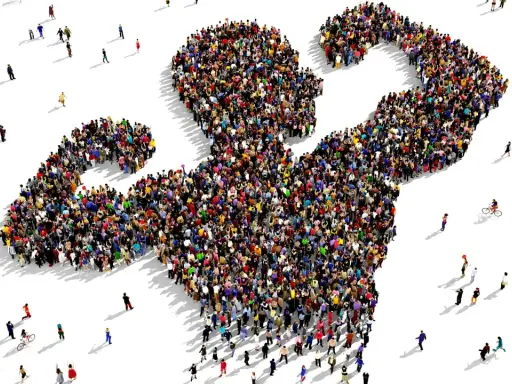 Een grote groep mensen vormt de gestalte van een gespierde arm, wat de kracht van de massa symboliseert. Dit beeld roept vragen op over wat is populisme en hoe de massa wordt gemobiliseerd.
