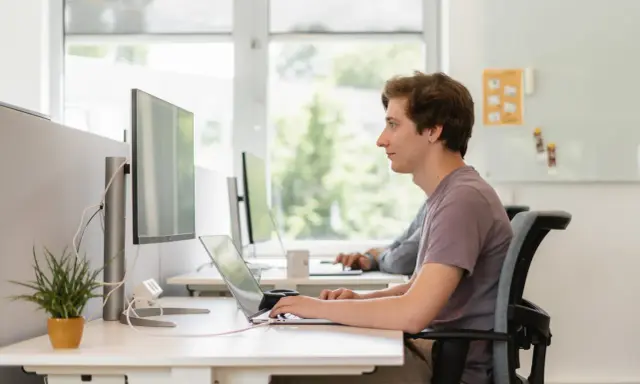 Jonge man werkt geconcentreerd aan laptop. Dit is een voorbeeld van self assessment betekenis: reflecteren op eigen werk.