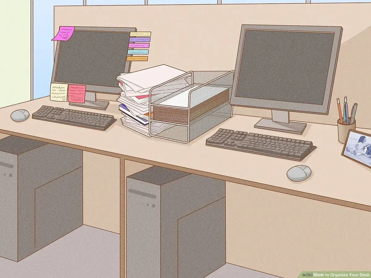 Twee computers met toetsenborden en muizen, een stapel papieren en een organizer. Dit is hoe je slimmer werken aanpakt.