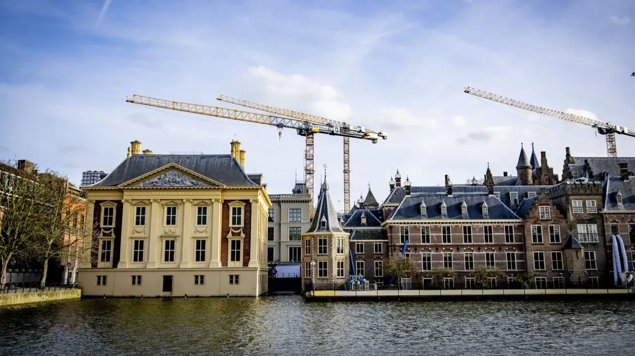 Bouwkranen boven het Binnenhof, waar wat zijn beleidsmakers druk bezig met het vormgeven van de toekomst.