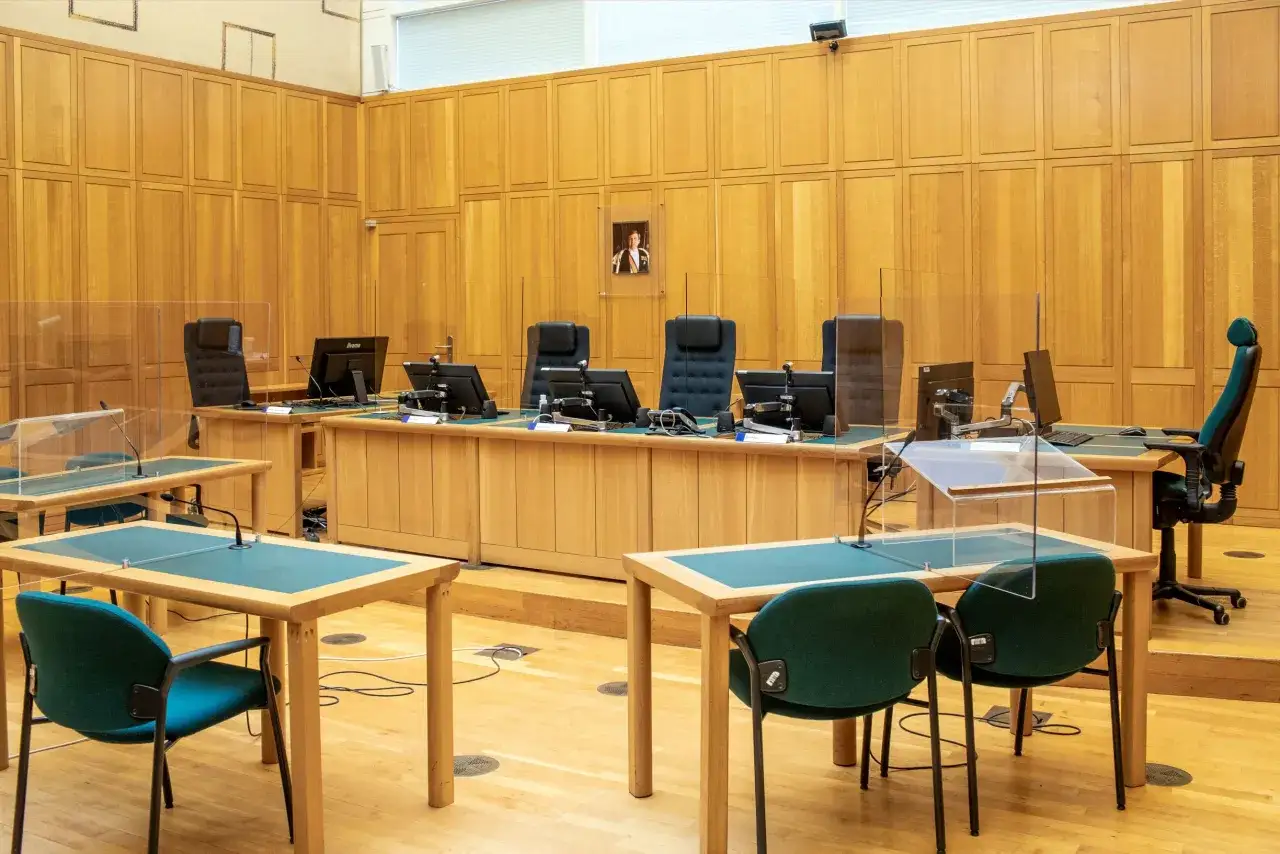 Rechtbankzaal met houten wanden. Hier wordt een kroongetuige ondervraagd, wat cruciaal kan zijn voor de zaak.