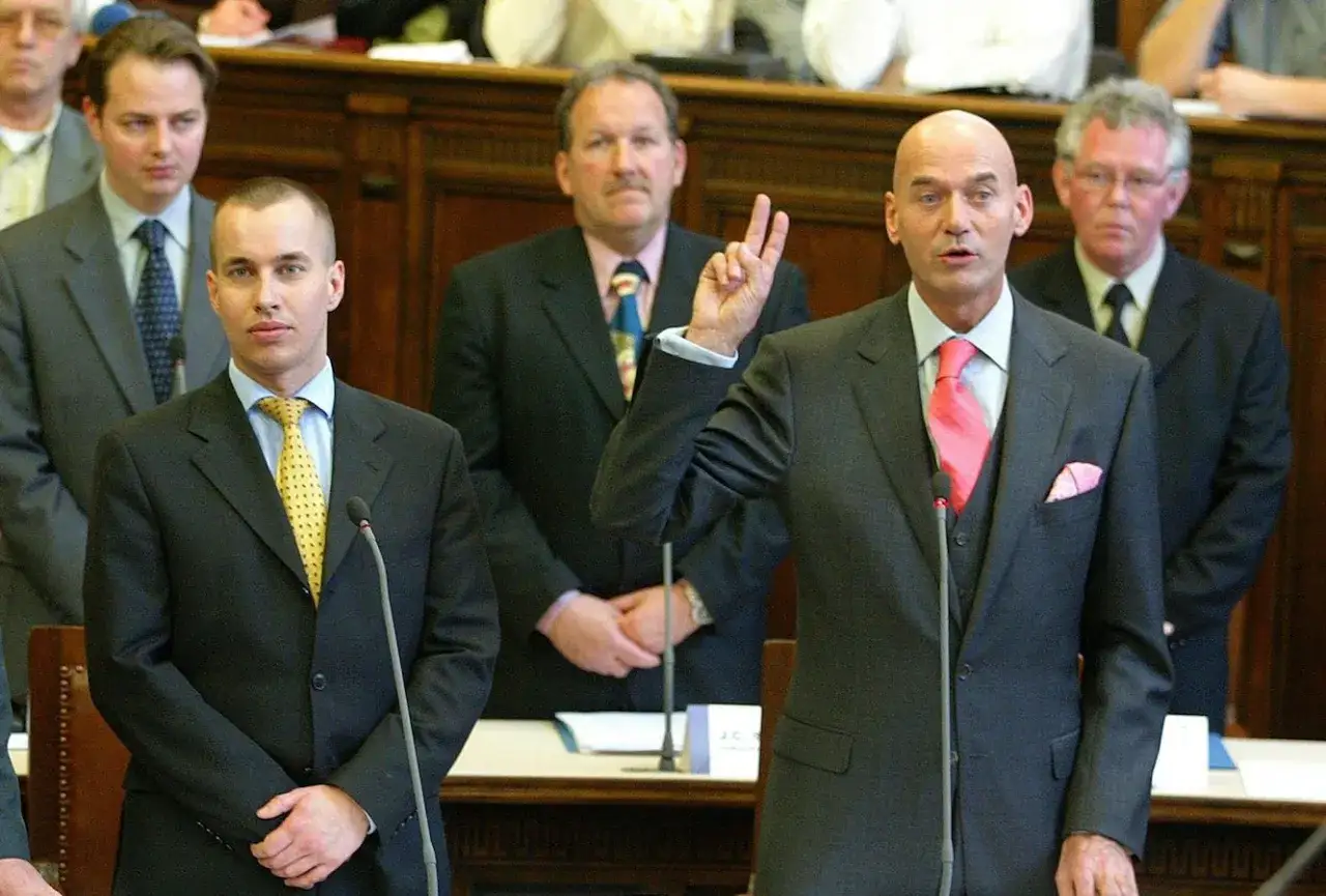 Pim Fortuyn's partij heette LPF. Hier spreekt hij in het parlement, omringd door collega's.