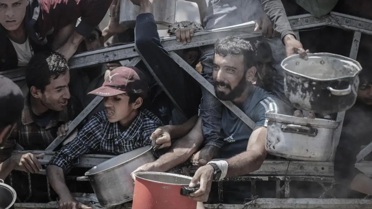 Mensen met potten en pannen, hopend op hulp. Dit is wat er gebeurt in Gaza: een strijd om basisbehoeften.
