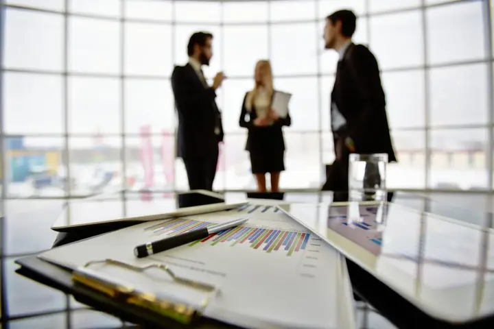 Een team bespreekt grafieken en cijfers, een vooruitblik op wat je kunt worden met bedrijfskunde: manager, strateeg of ondernemer.